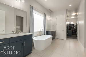 Bathroom featuring a tub, tile patterned flooring, and vanity