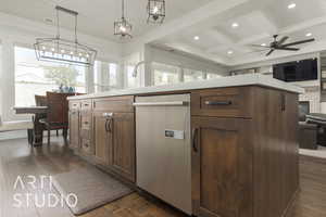 Kitchen featuring dark hardwood / wood-style flooring, a center island with sink, hanging light fixtures, and a healthy amount of sunlight