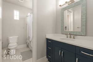 Bathroom featuring toilet, vanity, tile patterned floors, and curtained shower