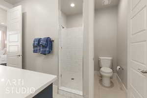 Bathroom with a tile shower, tile patterned flooring, and toilet