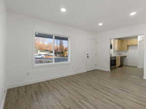 Unfurnished living room featuring sink and light wood-type flooring