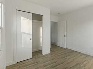 Unfurnished bedroom featuring a closet and light hardwood / wood-style floors