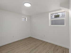 Basement featuring a wealth of natural light and light wood-type flooring