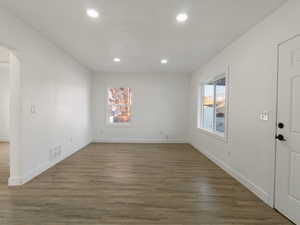 Spare room featuring dark hardwood / wood-style flooring and a healthy amount of sunlight