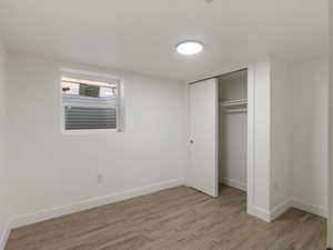 Unfurnished bedroom featuring light wood-type flooring and a closet