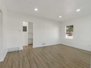 Spare room with wood-type flooring and electric panel