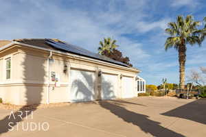 View of home's exterior with solar panels and a garage