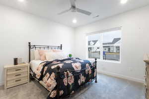 Carpeted bedroom featuring ceiling fan and multiple windows