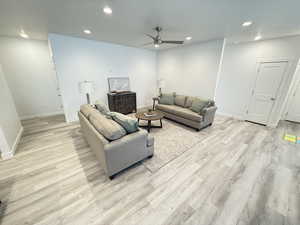 Living room with light hardwood / wood-style floors and ceiling fan