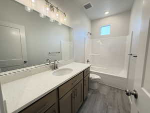 Full bathroom with wood-type flooring, vanity, toilet, and shower / bathtub combination