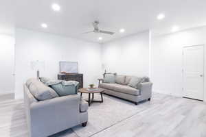 Living room with ceiling fan and light hardwood / wood-style floors