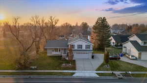 View of front of house featuring a lawn, a porch, and a garage