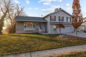 View of front of property featuring a front lawn and a garage