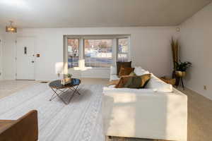 Living room featuring carpet floors and a notable chandelier