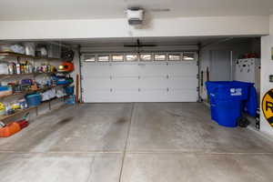 Garage featuring white fridge and a garage door opener