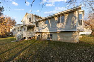 Back of property featuring a yard and cooling unit