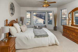 Bedroom with ceiling fan and light carpet