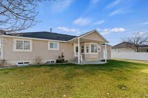 Rear view of house with a lawn and a patio