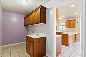 Kitchen featuring light tile patterned floors and sink