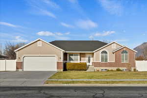 Ranch-style home featuring a garage and a front yard