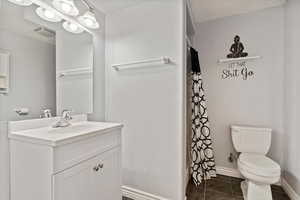 Bathroom featuring vanity, a textured ceiling, and toilet