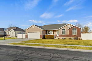 Ranch-style home with a front yard and a garage