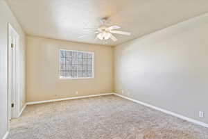 Carpeted Primary bedroom with ceiling fan