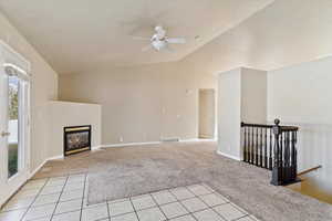 Unfurnished living room with light carpet, ceiling fan, and lofted ceiling