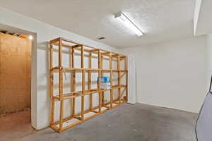 Basement storage area featuring a textured ceiling