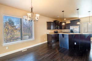 Kitchen with a wealth of natural light, decorative light fixtures, and appliances with stainless steel finishes