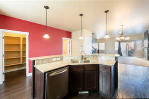 Kitchen with dark hardwood / wood-style flooring, dishwasher, dark brown cabinets, and sink