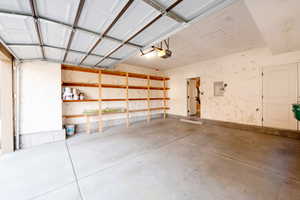 Garage featuring electric panel and a garage door opener