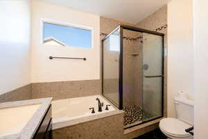 Full bathroom featuring plus walk in shower, vanity, and toilet