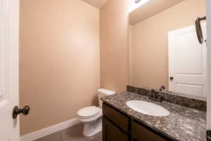 Bathroom featuring tile patterned flooring, vanity, and toilet