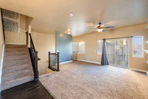 Unfurnished living room featuring dark hardwood / wood-style flooring and ceiling fan