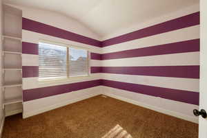 Carpeted empty room with lofted ceiling