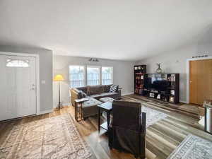 Living room with hardwood / wood-style flooring and lofted ceiling