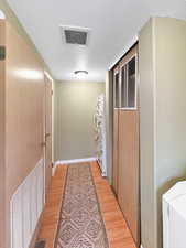 Corridor featuring light wood-type flooring and a textured ceiling