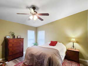 Bedroom featuring light hardwood / wood-style floors, vaulted ceiling, and ceiling fan