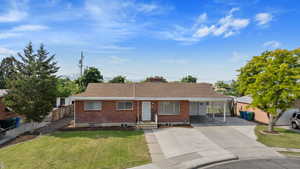 Single story home with a carport and a front lawn