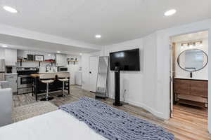 Living room featuring a textured ceiling, light laminate wood-style floors, washer / clothes dryer, and sink