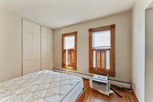 Bedroom featuring hardwood / wood-style flooring and a baseboard radiator