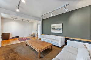 Living room featuring track lighting and dark wood-type flooring