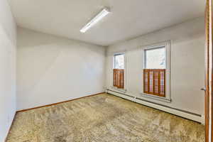 Carpeted spare room with baseboard heating