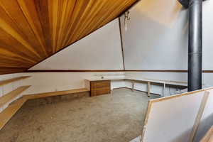 Additional living space with carpet, built in desk, and wooden ceiling