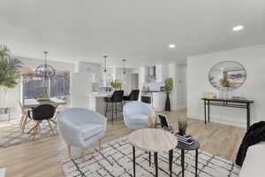 Living room with a notable chandelier and light hardwood / wood-style floors