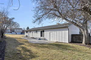 Rear view of house featuring central AC unit, a patio area, and a lawn