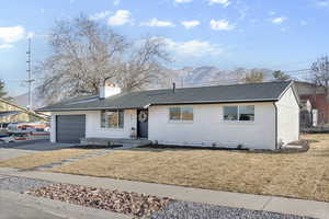 View of front of home featuring a mountain view, a front yard, and a garage