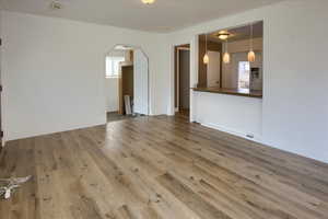 Unfurnished living room with hardwood / wood-style floors and a healthy amount of sunlight