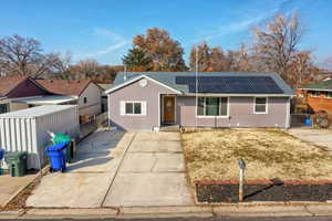 Single story home featuring solar panels